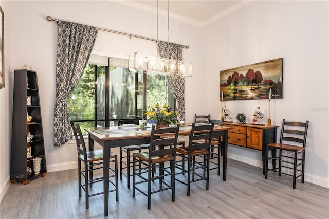 dining space with crown molding and hardwood / wood-style flooring