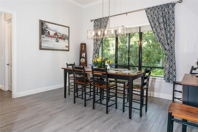 dining room with crown molding, wood-type flooring, and a chandelier