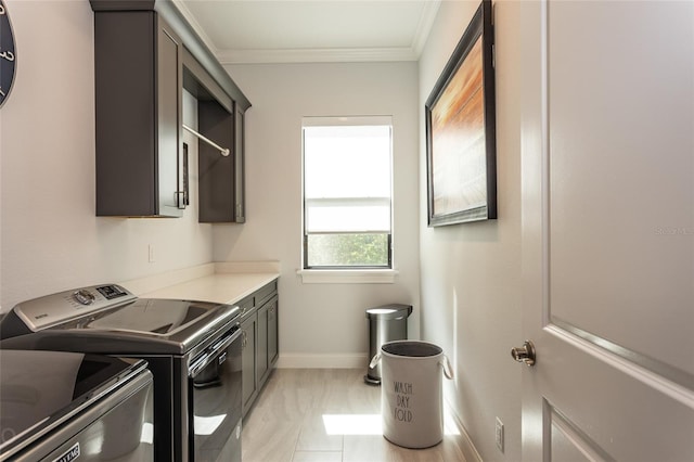 washroom with ornamental molding, cabinets, and washer and clothes dryer