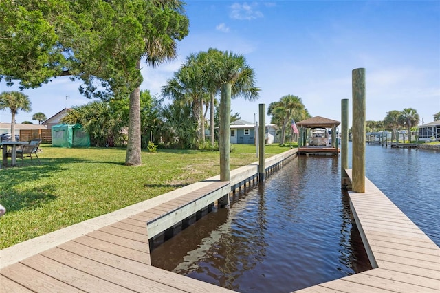 view of dock featuring a lawn and a water view