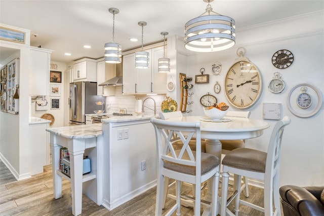 110 Ocean Hollow Ln Unit 101, Saint Augustine, FL 32084 - kitchen featuring open shelves, light wood-style flooring, white cabinetry, decorative backsplash, and light stone counters