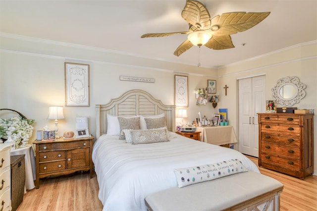 bedroom featuring crown molding, ceiling fan, light hardwood / wood-style flooring, and a closet