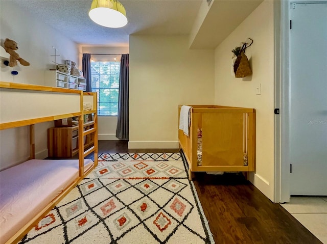 bedroom with a textured ceiling and hardwood / wood-style flooring