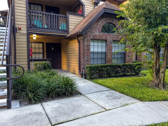 view of exterior entry with a balcony