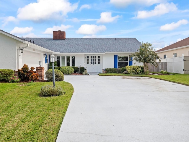 ranch-style house featuring a garage and a front lawn