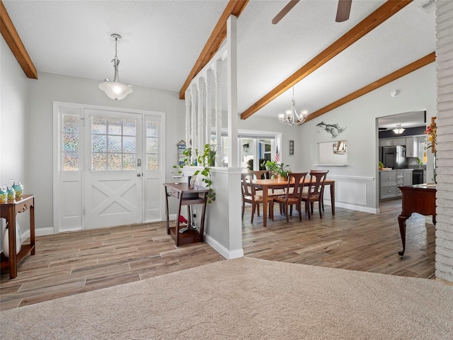 foyer entrance with ceiling fan, vaulted ceiling with beams, a textured ceiling, and light wood-type flooring