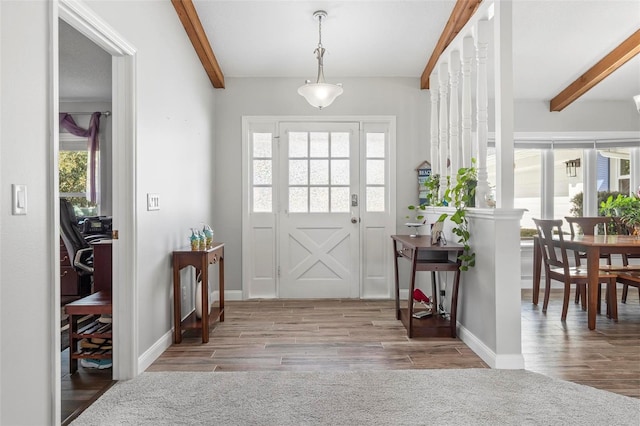 foyer entrance featuring light wood-type flooring and beam ceiling