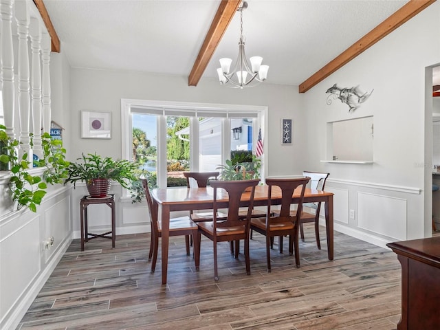 dining area featuring lofted ceiling with beams, dark wood-type flooring, and a notable chandelier