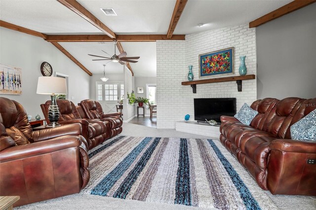 living room with a brick fireplace, carpet, vaulted ceiling with beams, ceiling fan, and brick wall