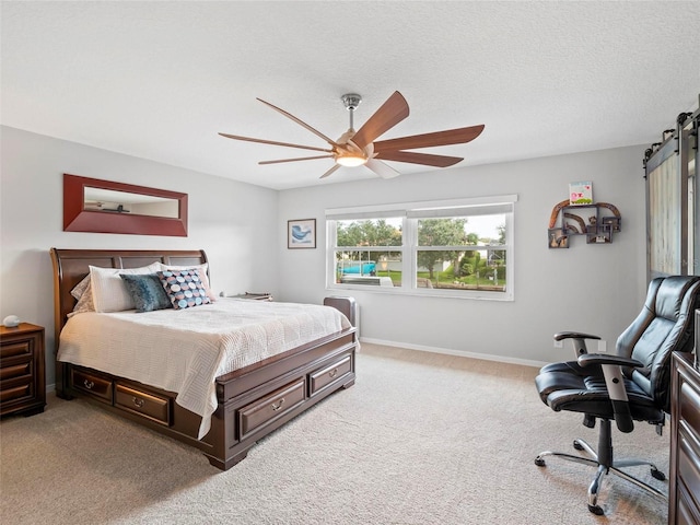 carpeted bedroom with ceiling fan and a textured ceiling