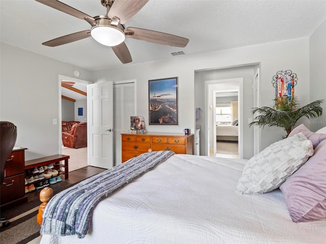 bedroom with a textured ceiling, ceiling fan, a closet, and hardwood / wood-style flooring