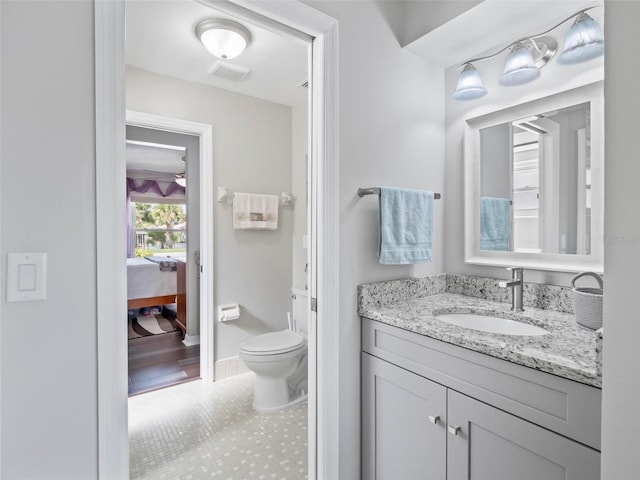 bathroom with vanity, toilet, and hardwood / wood-style flooring