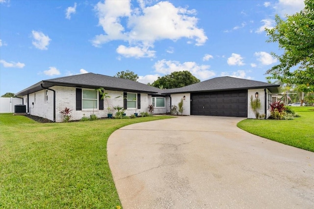 single story home featuring cooling unit, a garage, and a front yard