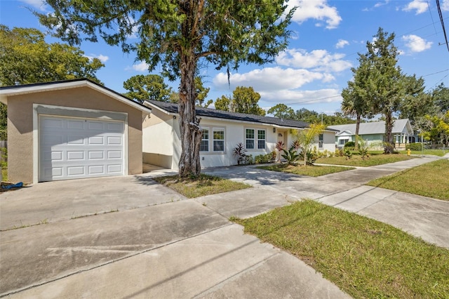 ranch-style house featuring a front lawn and a garage