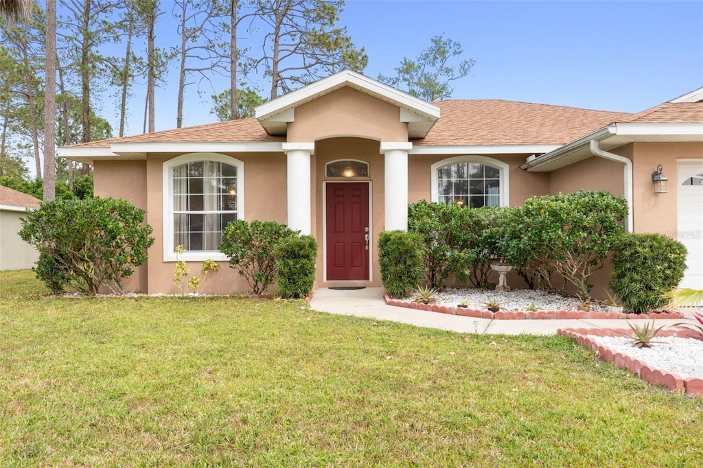 view of front of property featuring a front yard and a garage