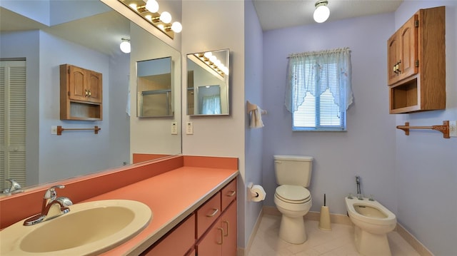 bathroom with a bidet, vanity, toilet, and tile patterned floors