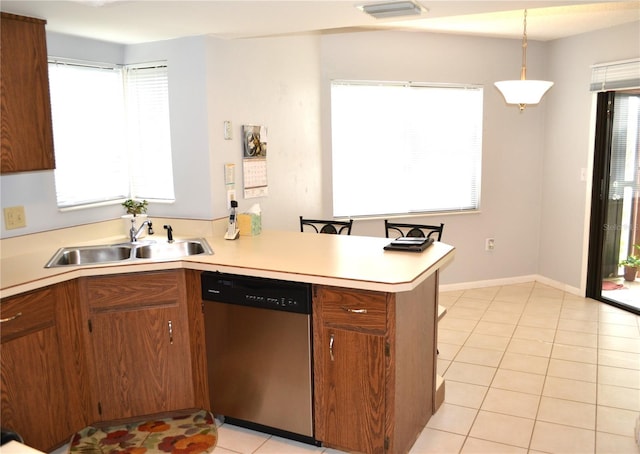 kitchen featuring kitchen peninsula, stainless steel dishwasher, a healthy amount of sunlight, sink, and hanging light fixtures