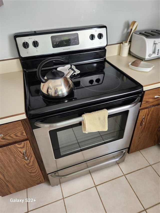 kitchen featuring electric stove and light tile patterned floors