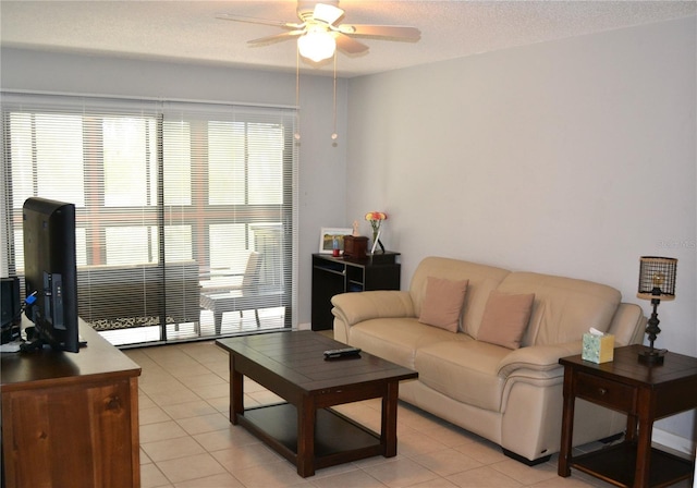 tiled living room featuring ceiling fan and a textured ceiling