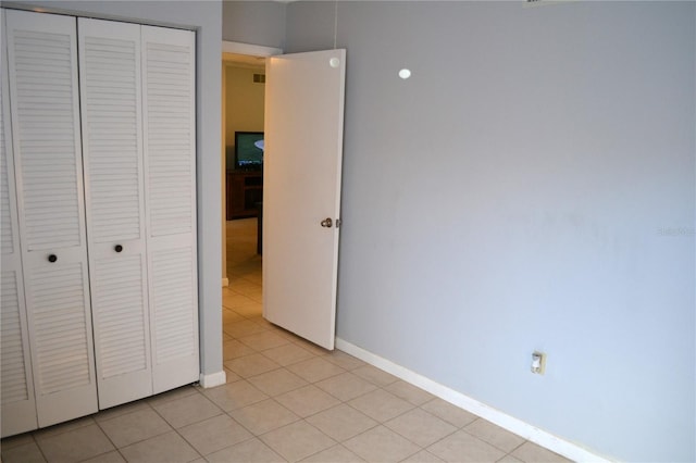 unfurnished bedroom featuring a closet and light tile patterned flooring