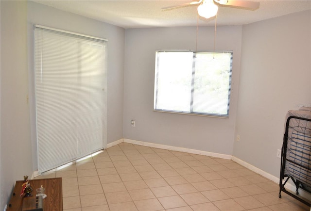 unfurnished bedroom featuring ceiling fan, light tile patterned floors, and a textured ceiling