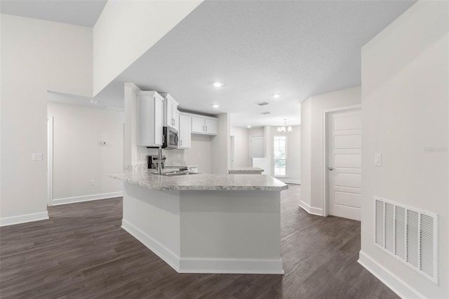 kitchen featuring sink, white cabinets, dark hardwood / wood-style flooring, stove, and light stone counters