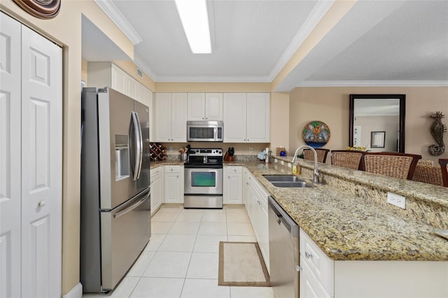 kitchen featuring appliances with stainless steel finishes, white cabinets, kitchen peninsula, a kitchen bar, and sink