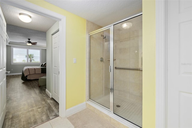 bathroom featuring a textured ceiling, wood-type flooring, and a shower with shower door