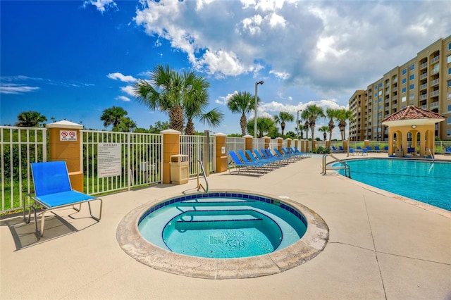 view of swimming pool featuring a community hot tub and a patio area