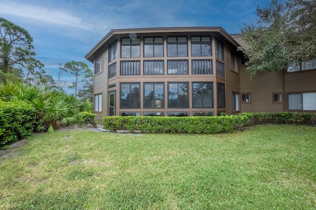 rear view of house featuring a lawn