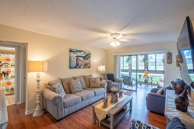 living room with ceiling fan, wood-type flooring, and a textured ceiling