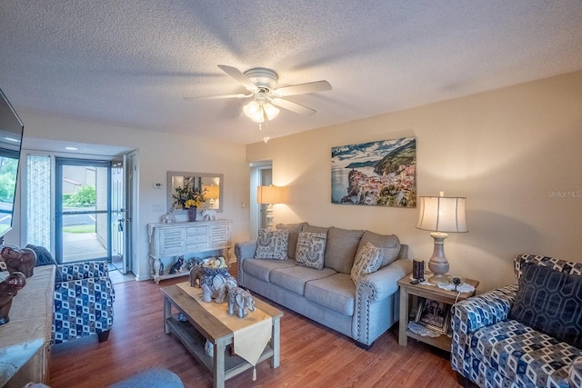 living room featuring a textured ceiling, wood-type flooring, and ceiling fan