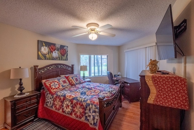 bedroom featuring light hardwood / wood-style floors, a textured ceiling, and ceiling fan