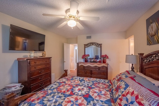 bedroom with ceiling fan and a textured ceiling