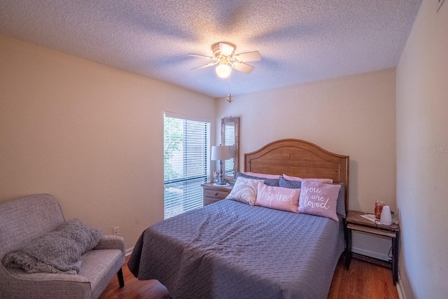 bedroom with hardwood / wood-style floors, a textured ceiling, and ceiling fan