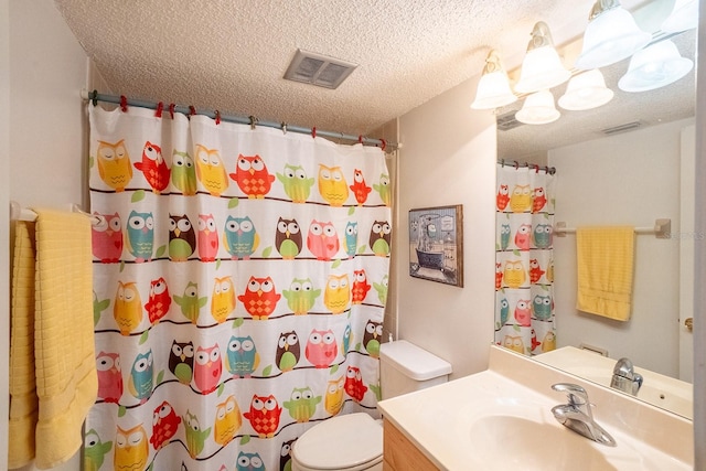 bathroom with vanity, toilet, a textured ceiling, and walk in shower