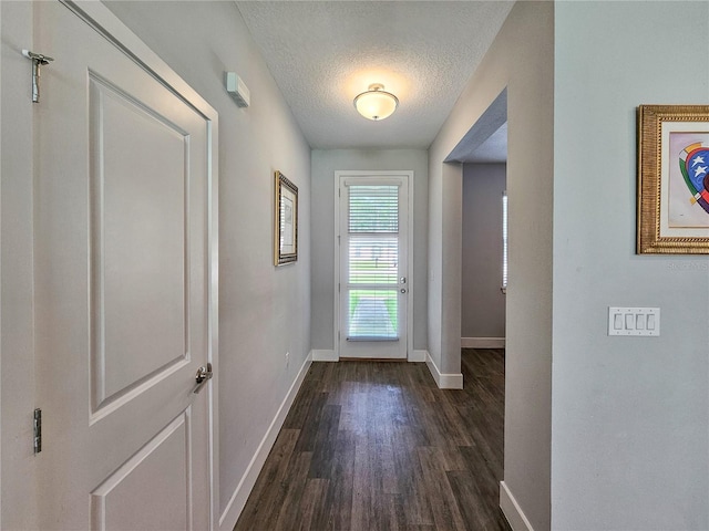 doorway to outside featuring a textured ceiling and dark hardwood / wood-style flooring