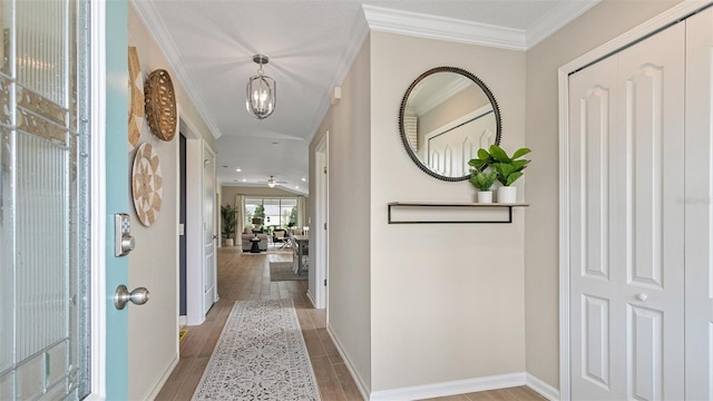 interior space featuring a notable chandelier, light wood-type flooring, and crown molding