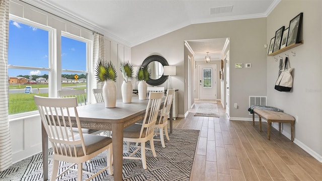 dining area featuring light hardwood / wood-style floors, plenty of natural light, and crown molding