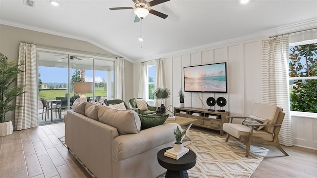 living room featuring ornamental molding, light wood-type flooring, vaulted ceiling, and ceiling fan