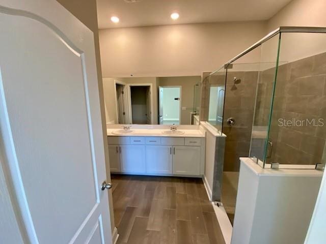 bathroom with vanity, wood-type flooring, and walk in shower