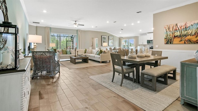 dining room featuring a wealth of natural light, ceiling fan, light wood-type flooring, and crown molding