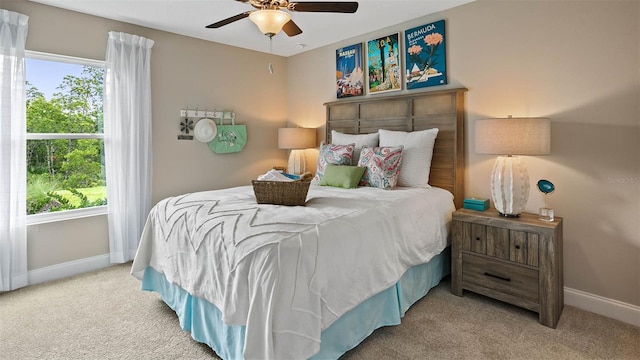 carpeted bedroom featuring multiple windows and ceiling fan