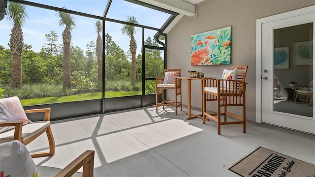 sunroom / solarium with vaulted ceiling with beams