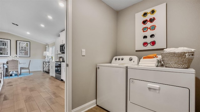 laundry room featuring crown molding, washing machine and clothes dryer, and light hardwood / wood-style flooring