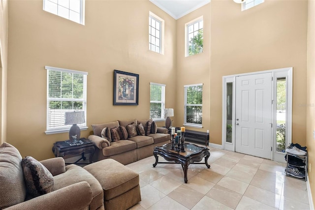 living room with ornamental molding, a towering ceiling, and a healthy amount of sunlight