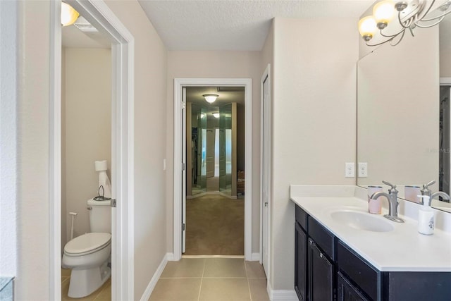 bathroom featuring an inviting chandelier, tile patterned flooring, a textured ceiling, toilet, and vanity