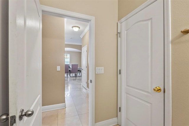 corridor with ornamental molding and light tile patterned floors