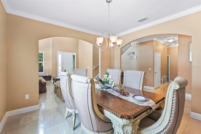 tiled dining area with crown molding and an inviting chandelier