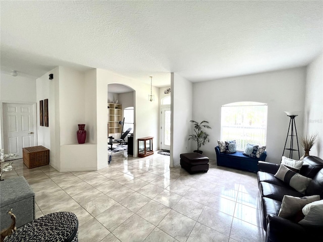 tiled living room featuring a textured ceiling